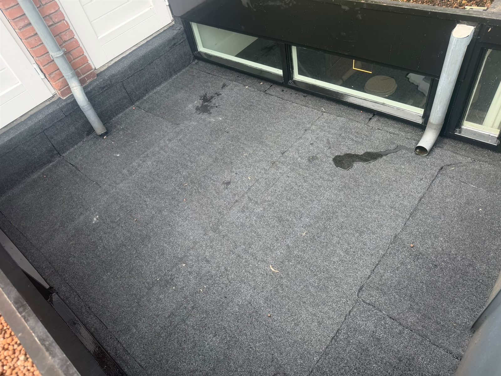 Overzicht van het bitumen dak langs de gevel van de binnenplaats
