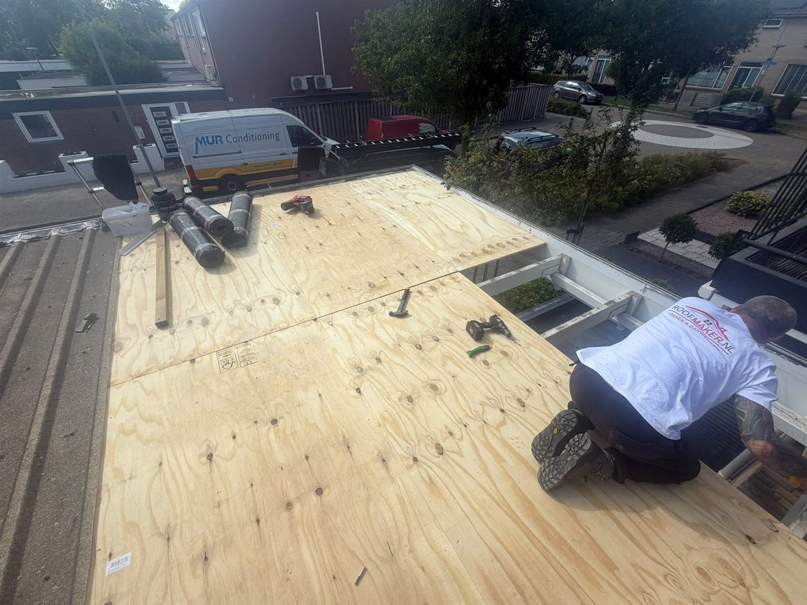 Werkzaamheden tijdens de aanleg van het bitumen dak van de aanbouw
