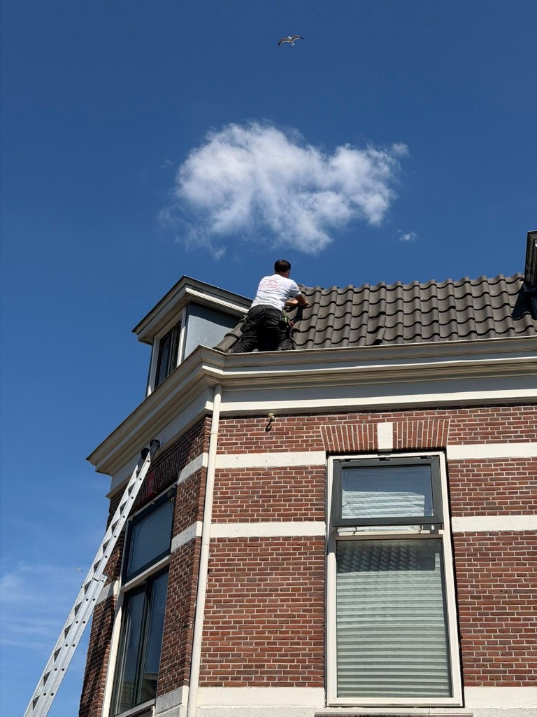 Dakdekker aan het werk op pannendak in Utrecht