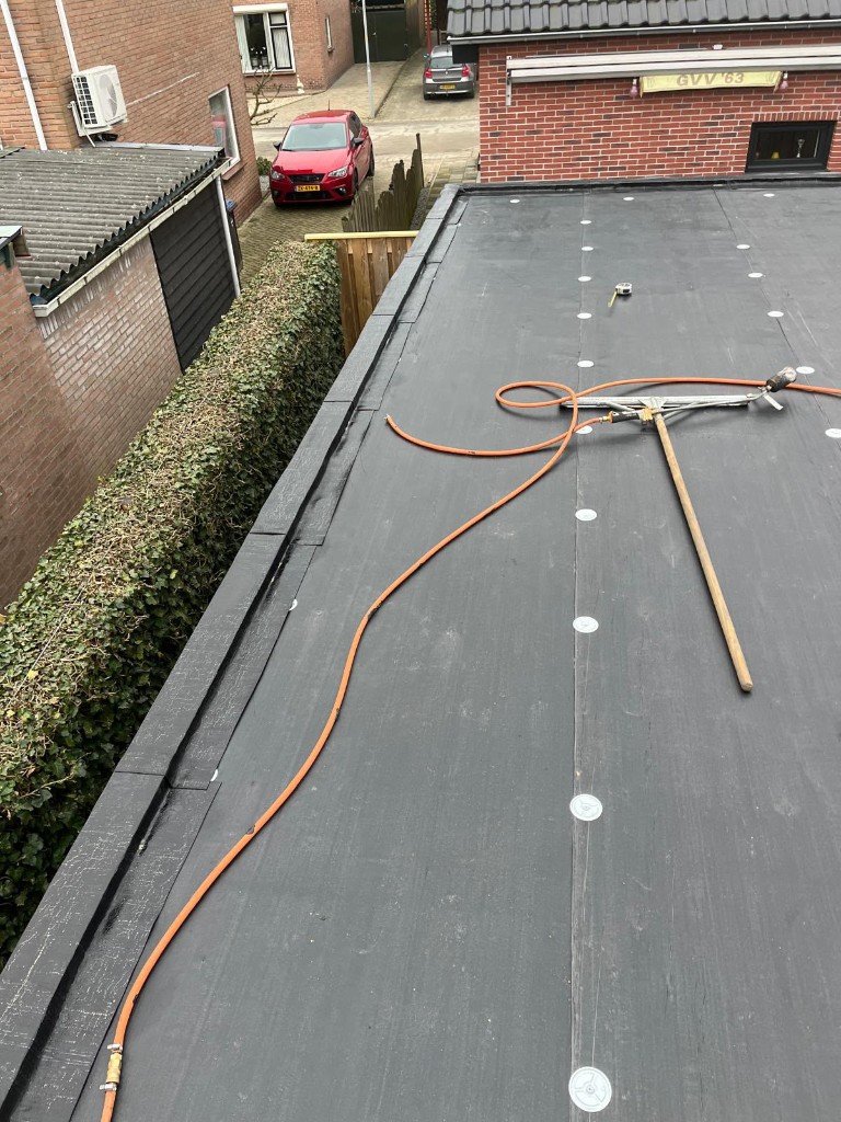 Nieuwe onderlaag bevestigd op het platte dak van de berging